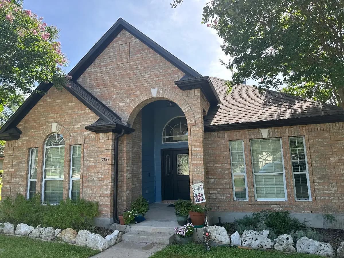 Painted brick home with dark gray trim by Ranger Painting in Cedar Park