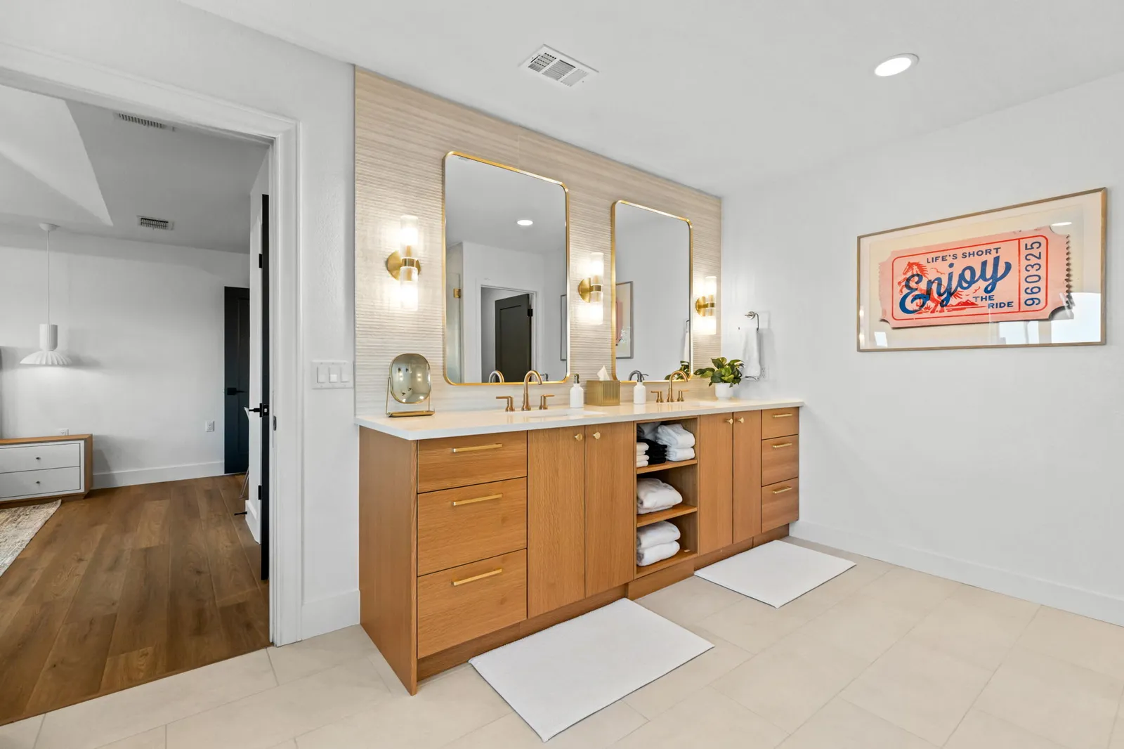 Spacious bathroom with a natural oak double vanity, gold-framed mirrors and freshly painted white walls by Ranger Painting in Austin