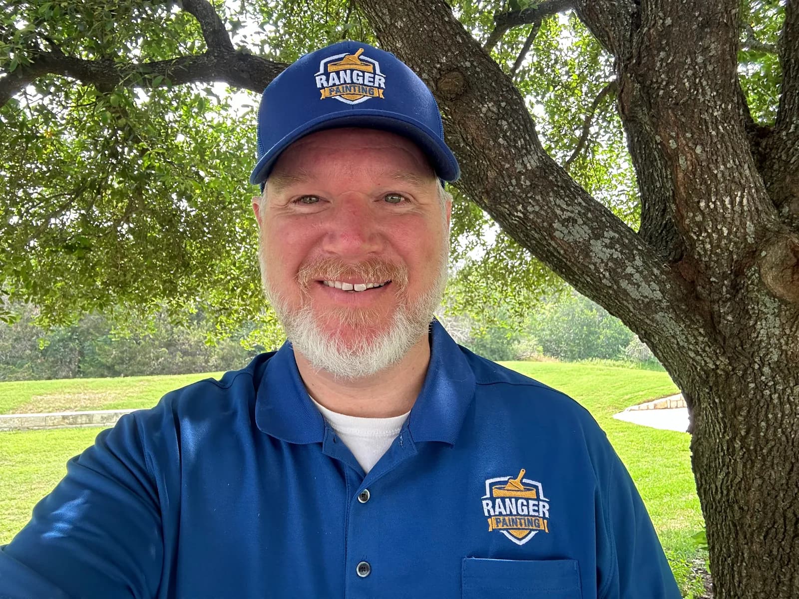 Nathan Wingate of Ranger Painting in a Ranger cap and polo shirt